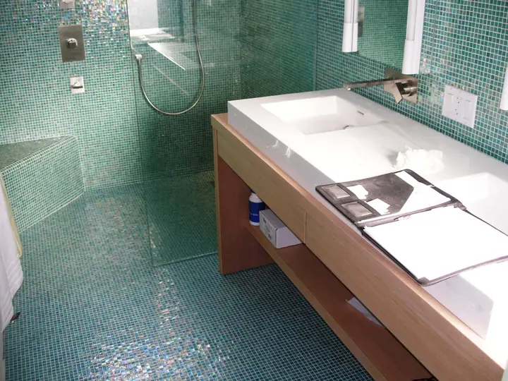Penthouse primary bath reorientation with glass tile in Oakland: vanity looking east