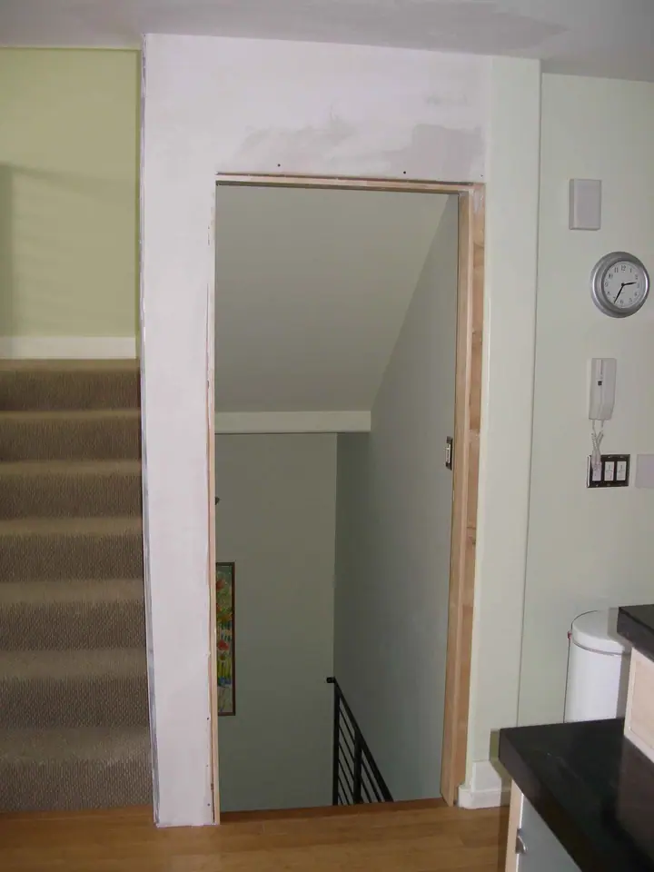 Retrofit wall to isolate an open stairway for privacy, Mission District, San Francisco: new doorway