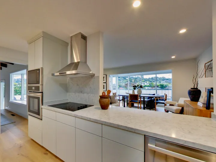 Kitchen counter and cooktop open to the dining area and the view