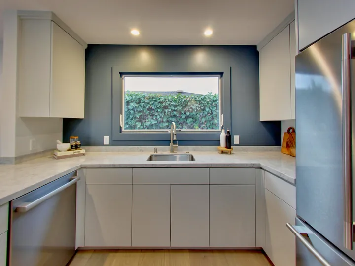 Kitchen sink wall with quartz counters and flat-panel cabinets