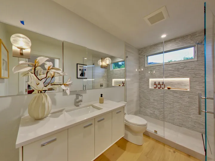 Primary bathroom with a long vanity and a glass walk-in shower