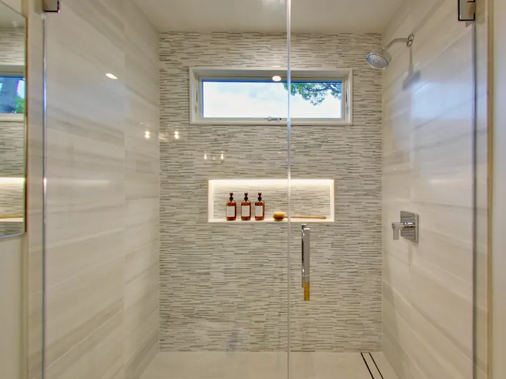 Walk-in shower with a lit niche and a clerestory window